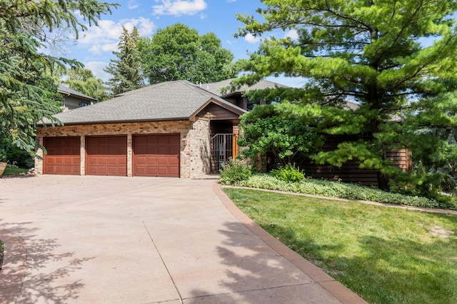 view of front of property with a garage, concrete driveway, a shingled roof, a front lawn, and brick siding