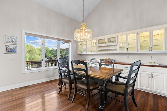 dining space with high vaulted ceiling, a chandelier, dark wood-style floors, and baseboards