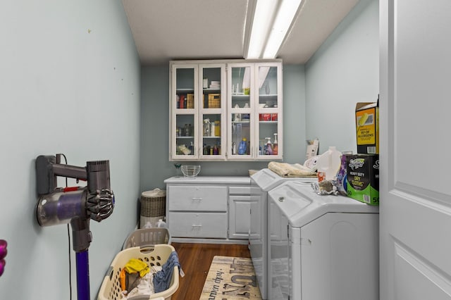 washroom with washer and dryer, cabinet space, and dark wood-style floors
