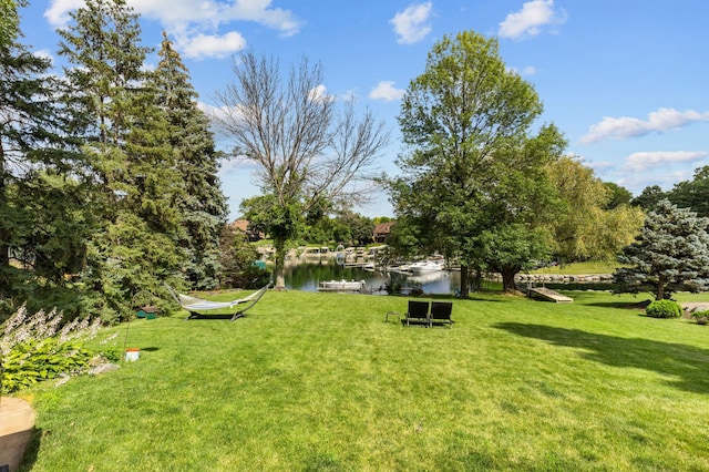 view of green lawn with a water view