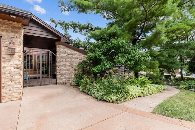 exterior space featuring a gate and brick siding
