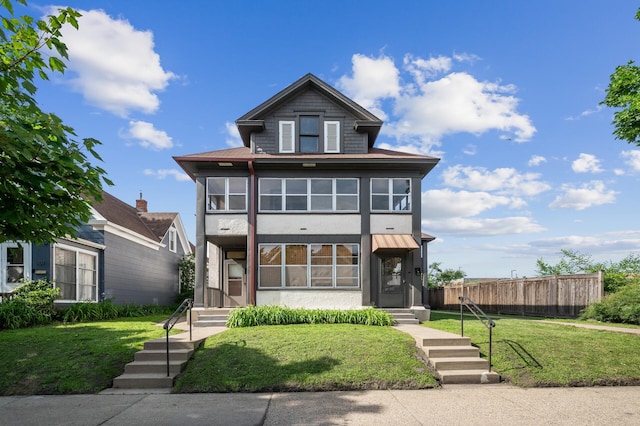 view of front of property with fence, a front yard, and stucco siding