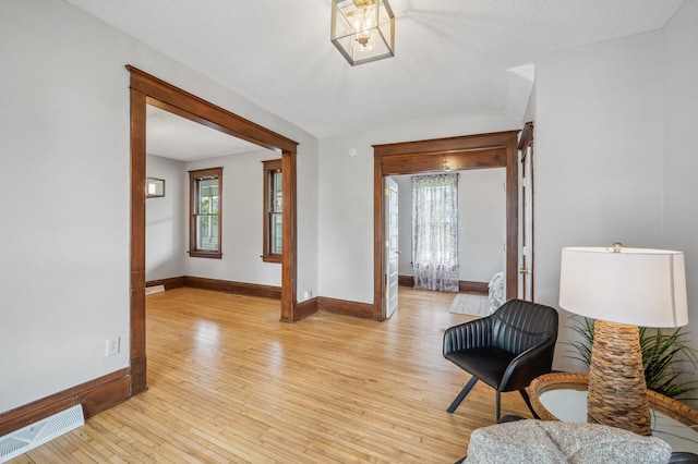 sitting room with visible vents, baseboards, a healthy amount of sunlight, and light wood-style floors
