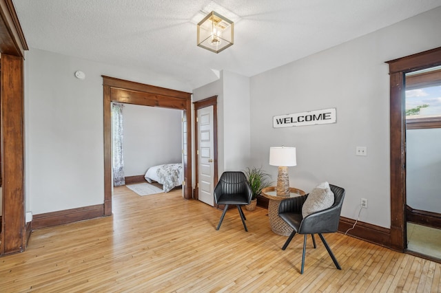 living area with baseboards and hardwood / wood-style floors