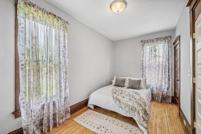 bedroom featuring a closet, baseboards, and hardwood / wood-style floors