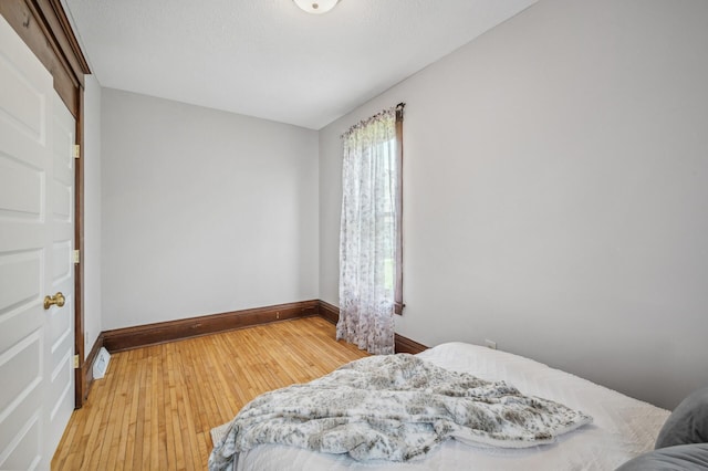 bedroom with baseboards and hardwood / wood-style floors