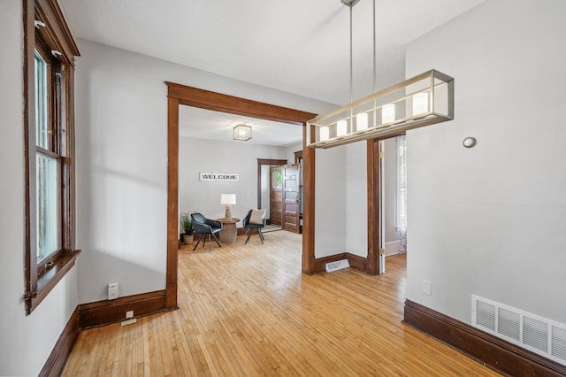 interior space with baseboards, visible vents, and light wood-style floors
