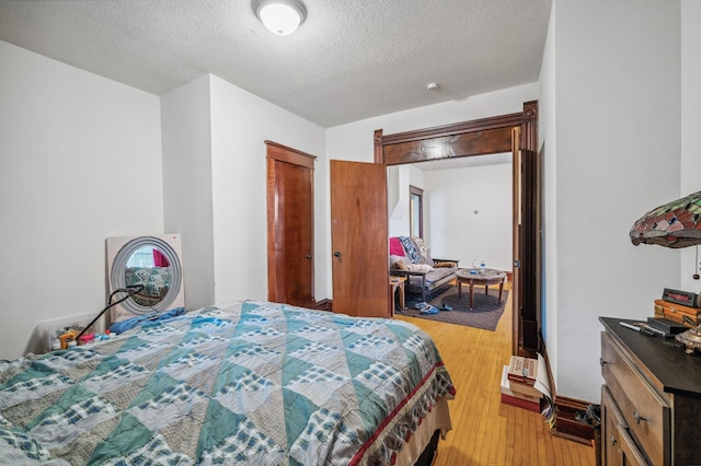 bedroom featuring light wood-type flooring and a textured ceiling