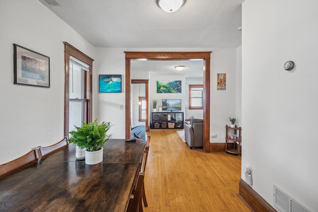 hallway with light wood-style floors and visible vents