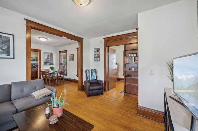 living area with baseboards and light wood finished floors