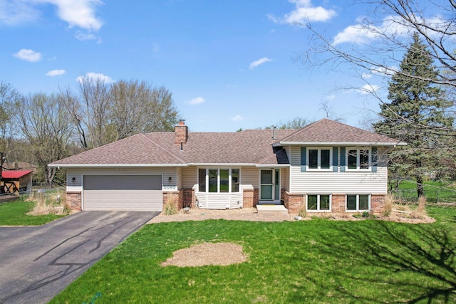 tri-level home featuring brick siding, an attached garage, aphalt driveway, and a chimney