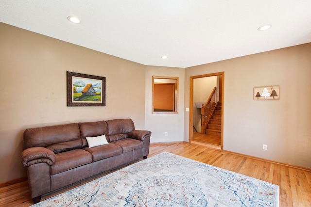 living room with stairs, recessed lighting, baseboards, and light wood-style flooring