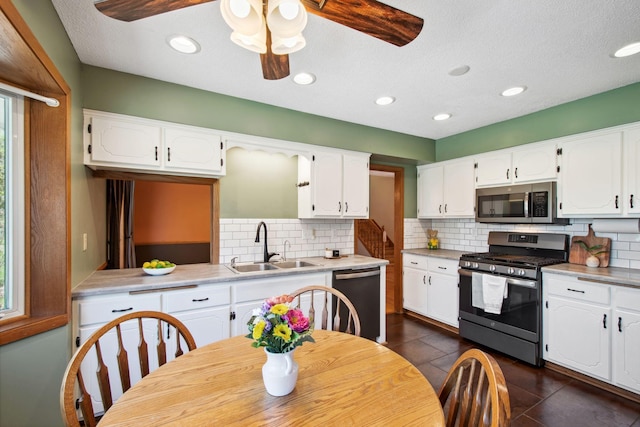 kitchen featuring a ceiling fan, tasteful backsplash, a sink, white cabinets, and stainless steel appliances