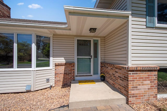 property entrance featuring brick siding and a chimney