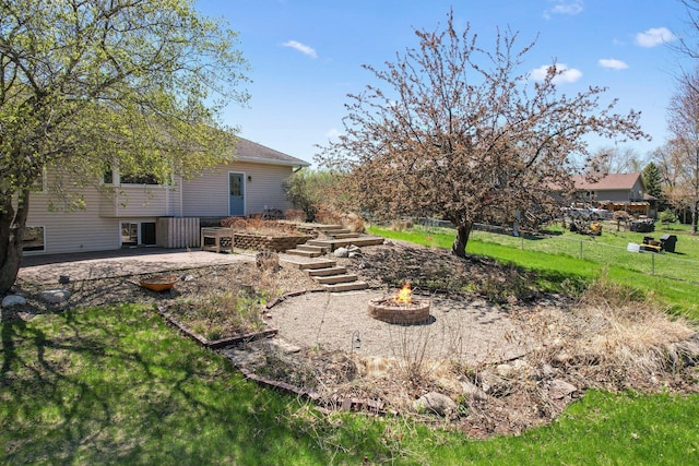 view of yard featuring a patio, a fire pit, and fence