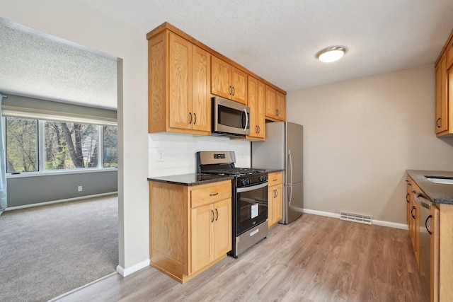 kitchen with baseboards, stainless steel appliances, and visible vents