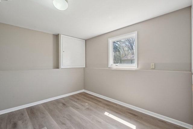 empty room featuring baseboards and light wood-type flooring