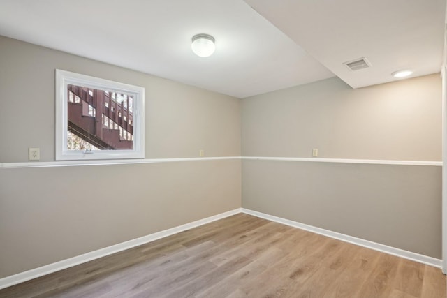 unfurnished room with visible vents, baseboards, and wood finished floors