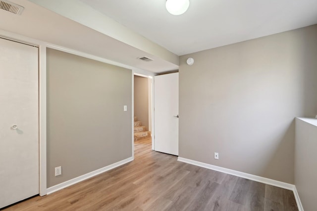 unfurnished bedroom featuring visible vents, baseboards, and wood finished floors