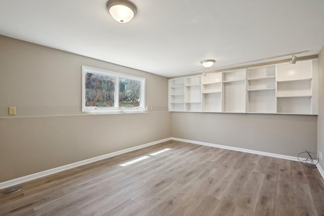 unfurnished room featuring baseboards and wood finished floors