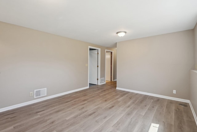 unfurnished room with visible vents, baseboards, and light wood-style floors
