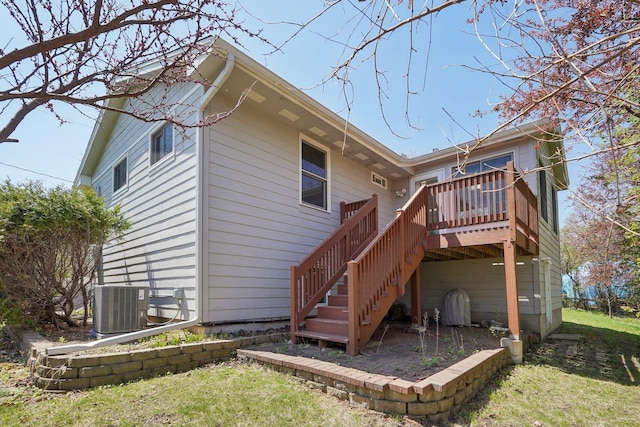 back of house featuring stairs, a lawn, a wooden deck, and cooling unit