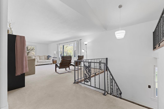 hallway with carpet floors and an upstairs landing