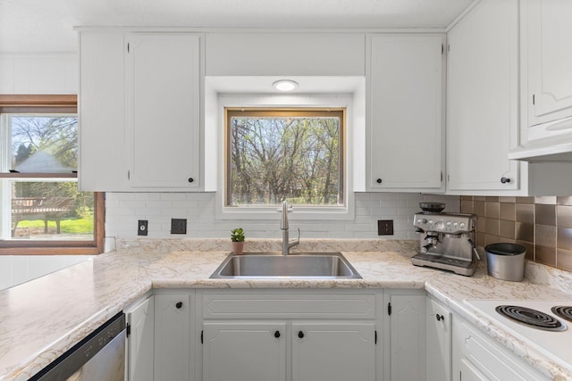 kitchen with white cabinets, a sink, white electric cooktop, under cabinet range hood, and stainless steel dishwasher