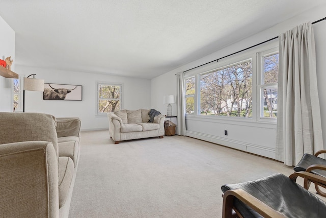 carpeted living area with a healthy amount of sunlight, baseboards, and a baseboard radiator