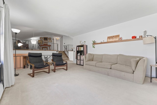 carpeted living room featuring stairway and lofted ceiling