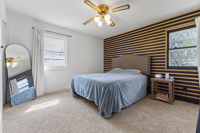 bedroom featuring wallpapered walls, multiple windows, and an accent wall