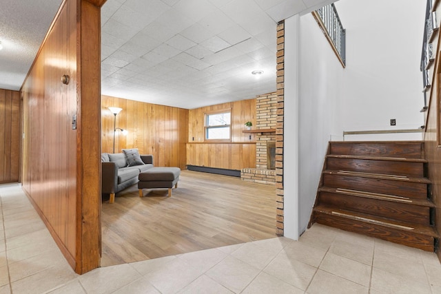 living area featuring stairs and wooden walls