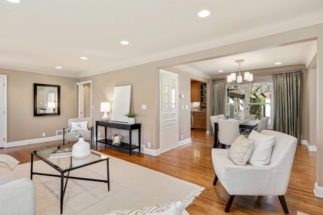living area featuring recessed lighting, baseboards, and a notable chandelier