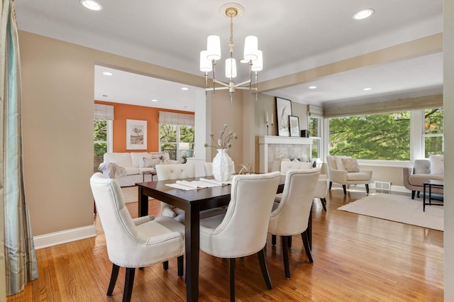 dining room with baseboards, recessed lighting, light wood-style flooring, and a notable chandelier