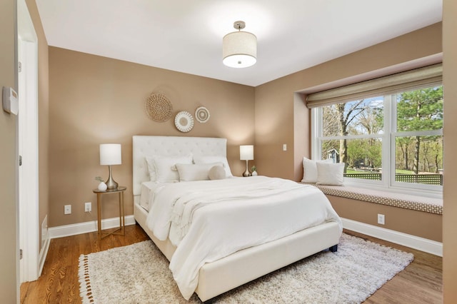 bedroom featuring baseboards and wood finished floors