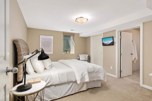 bedroom with baseboards, light carpet, and visible vents