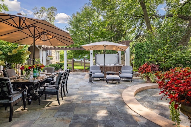 view of patio featuring fence, outdoor dining space, and a hot tub