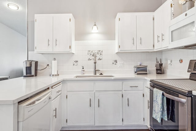 kitchen with a sink, decorative backsplash, white cabinets, and white appliances