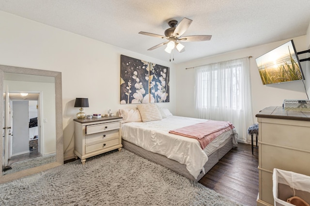 bedroom with ceiling fan, a textured ceiling, and wood finished floors