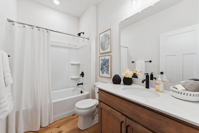 bathroom featuring toilet, wood finished floors, shower / tub combo with curtain, and vanity