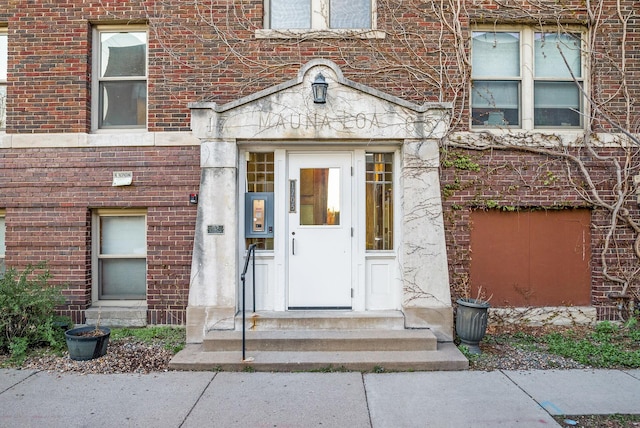 property entrance featuring brick siding