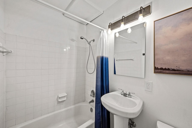 bathroom featuring a sink, toilet, and shower / tub combo