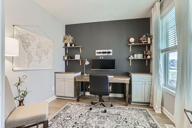 home office featuring baseboards, plenty of natural light, and light wood-type flooring
