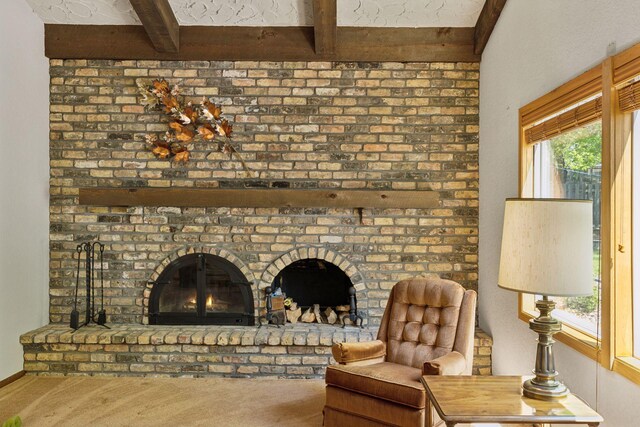 sitting room featuring beam ceiling and carpet
