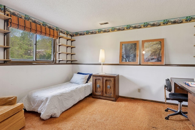 bedroom with carpet floors, an office area, and a textured ceiling
