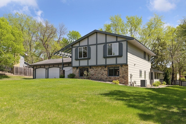 rear view of property featuring central AC unit, a garage, and brick siding