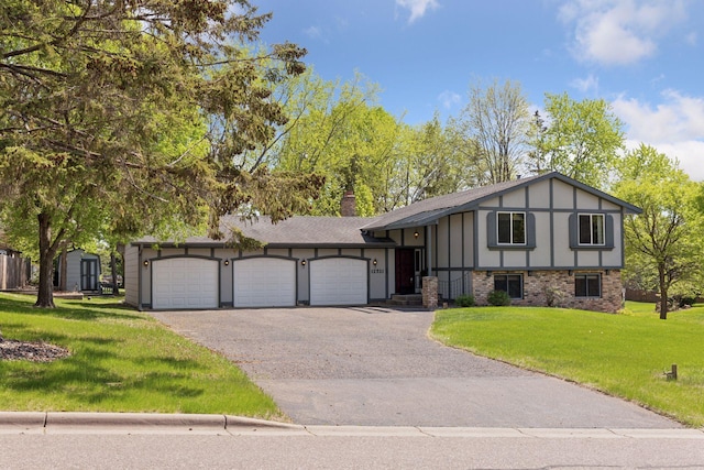 view of front of property featuring an attached garage, a front lawn, driveway, and brick siding