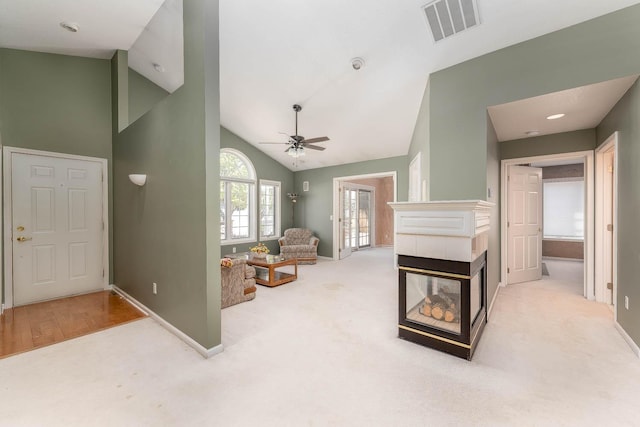 267 Plum Run, Le Sueur, MN 56058 - carpeted living room with visible vents, baseboards, high vaulted ceiling, and a tile fireplace