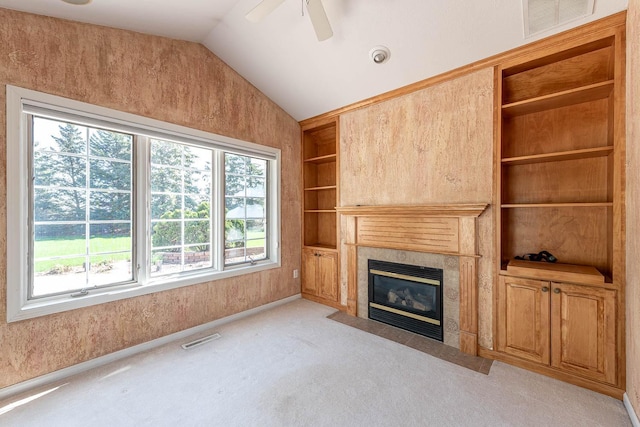 267 Plum Run, Le Sueur, MN 56058 - unfurnished living room with visible vents, light colored carpet, built in features, vaulted ceiling, and a tile fireplace