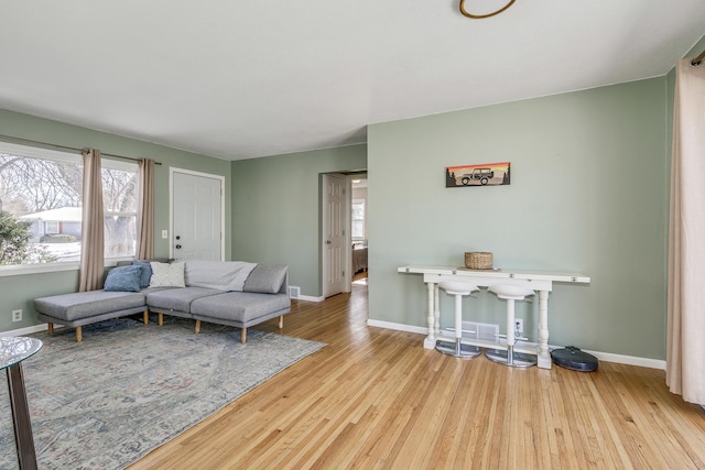 living area featuring a wealth of natural light, baseboards, and wood finished floors